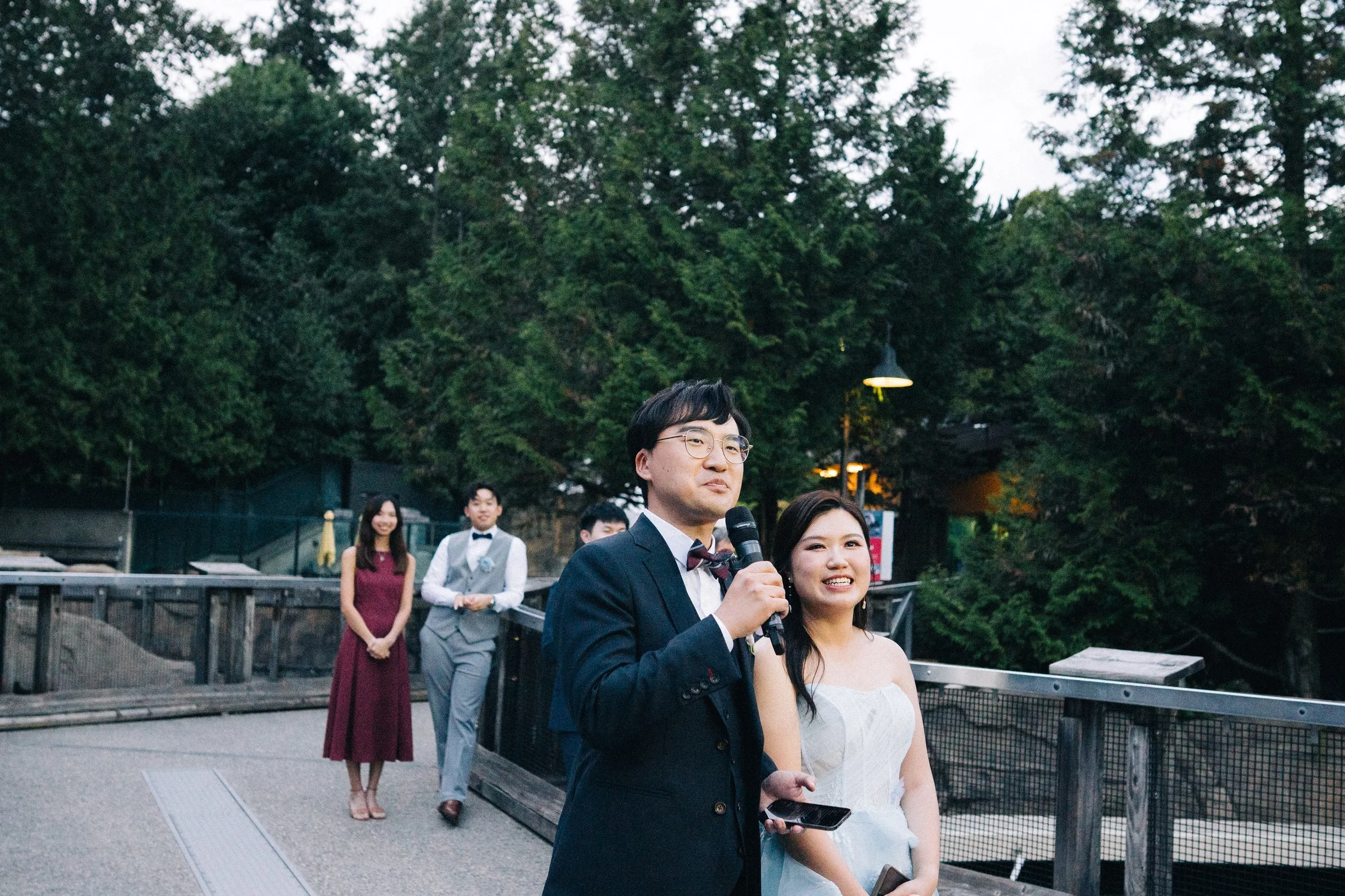 Bride and groom smiling together beside the aquarium pool railing.