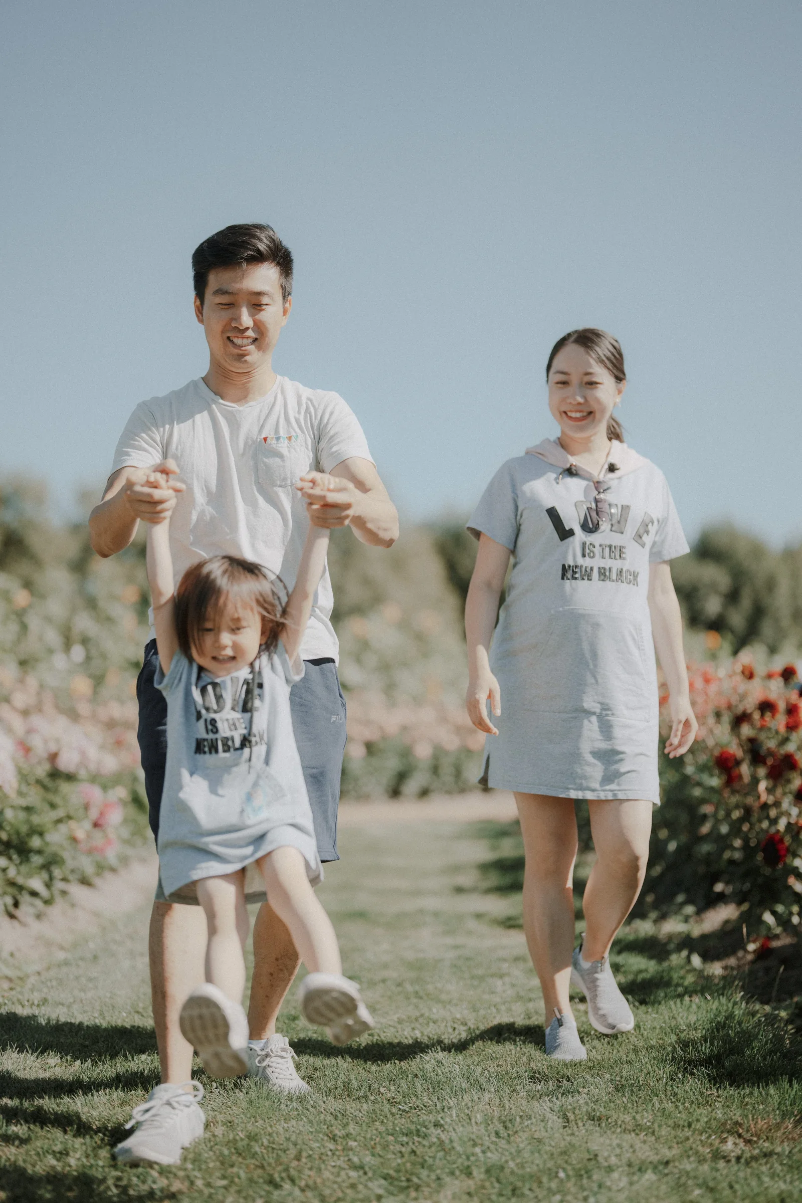 Family walking outdoors with child lifted playfully at Richmond Country Farms