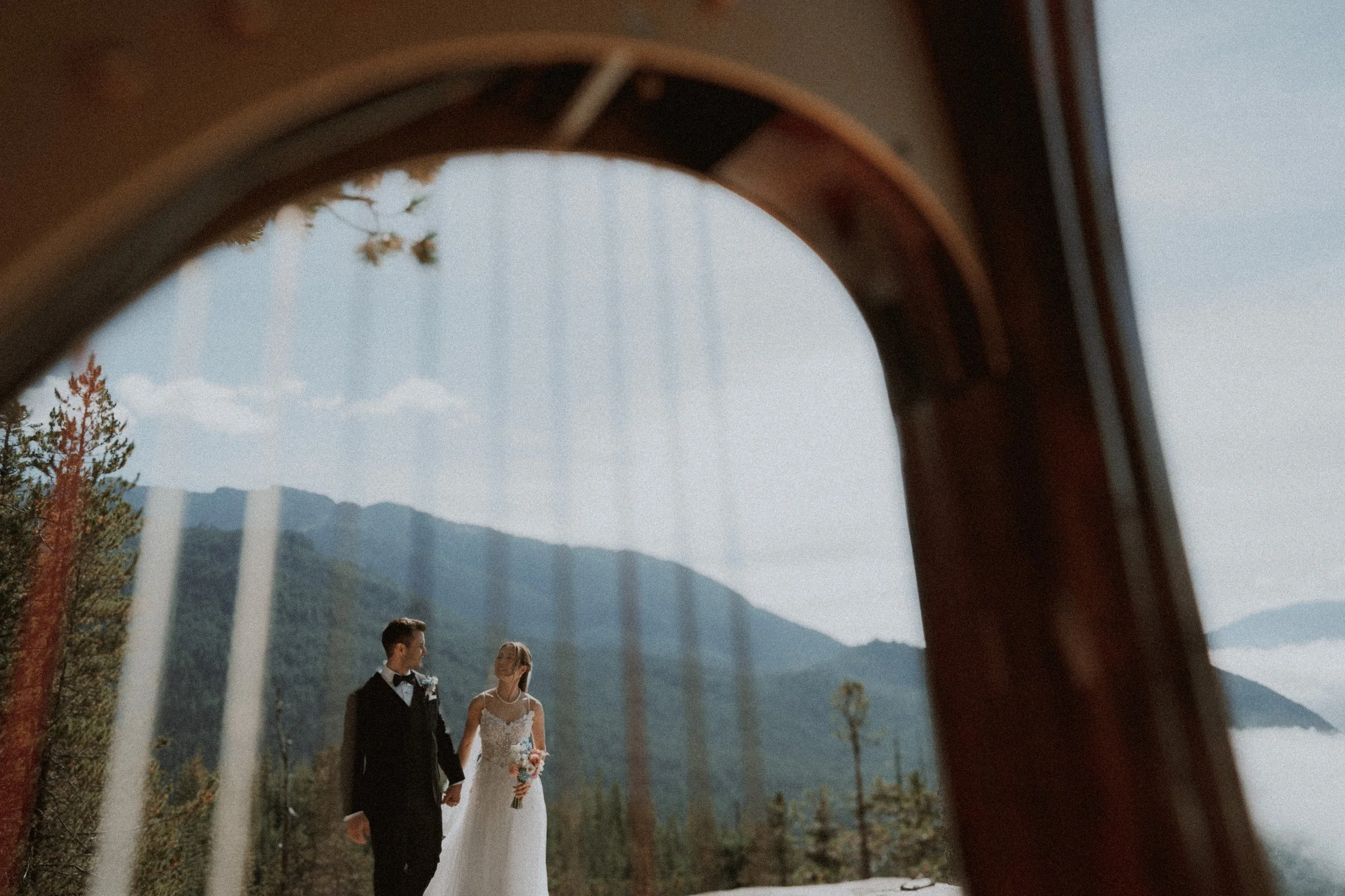 Couple's mountain wedding portrait reflected in a wood-framed mirror.