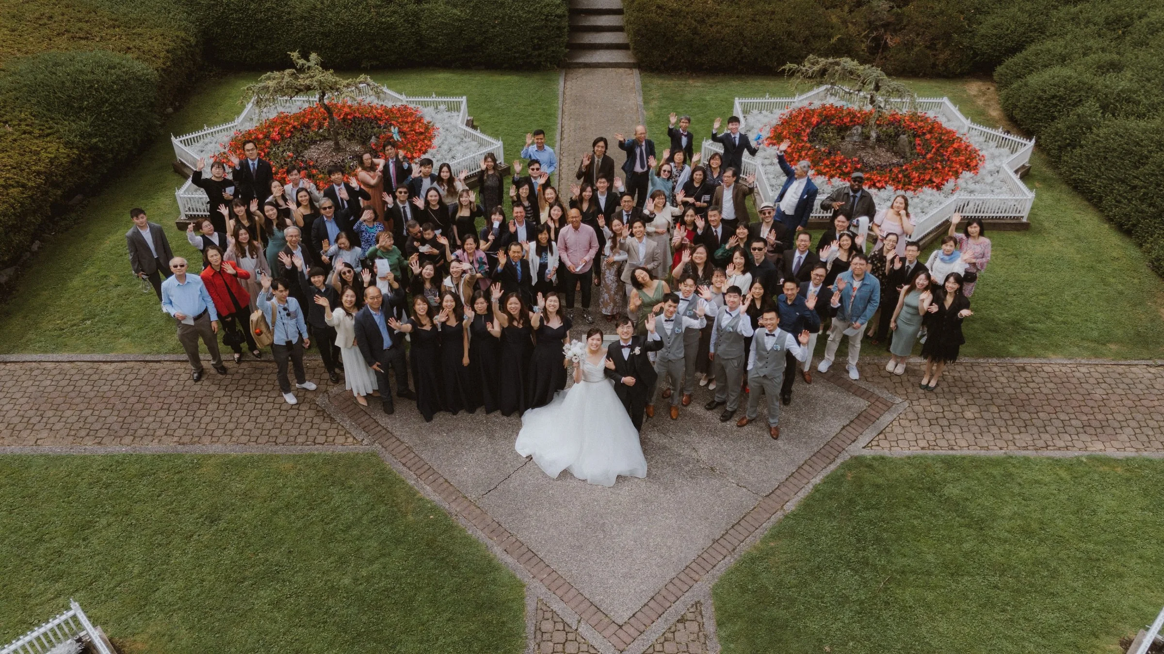 Minoru Chapel grounds large group photo, aerial view of wedding guests and couple.
