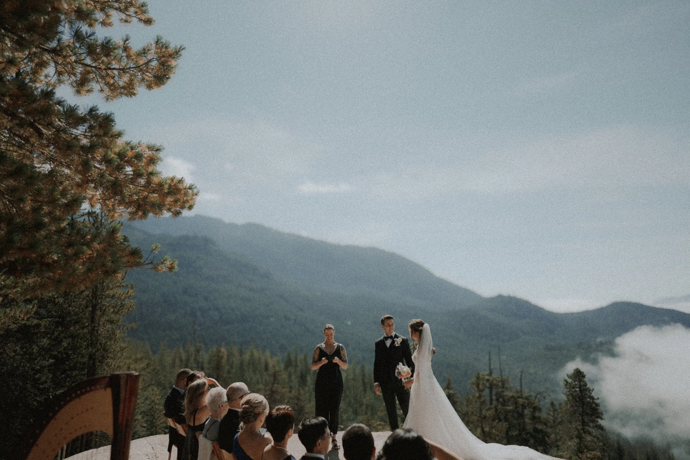 Wide view of the mountain wedding ceremony with a harp in the foreground.