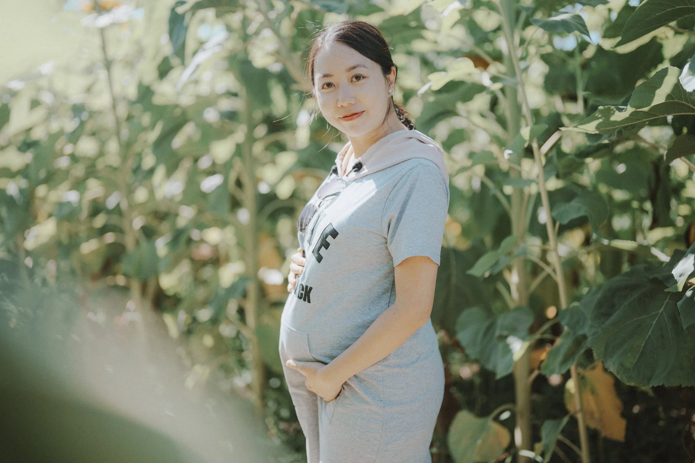 Pregnant woman standing in lush green garden at Richmond Country Farms