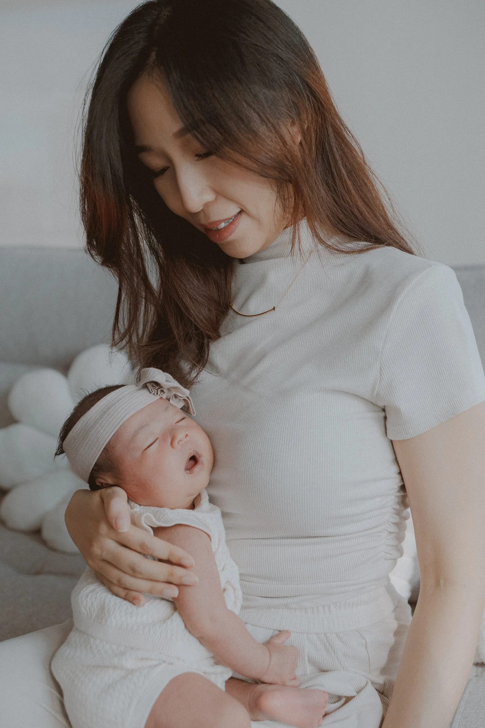 Parent looking down at a newborn held against their chest.