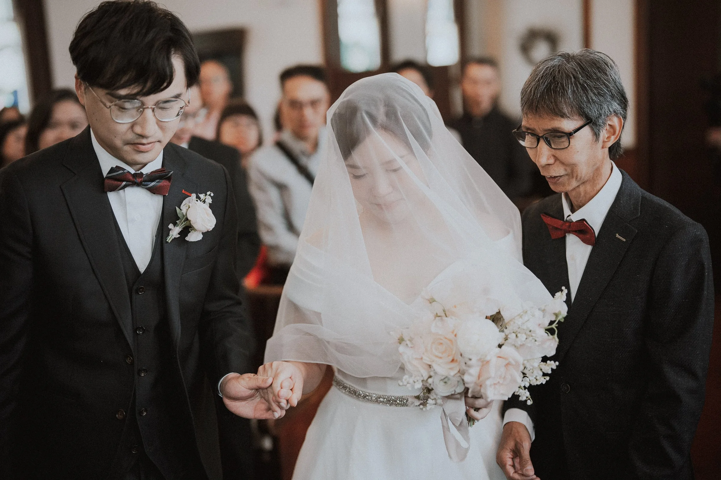 Bride between the groom and an accompanying guest during the ceremony.