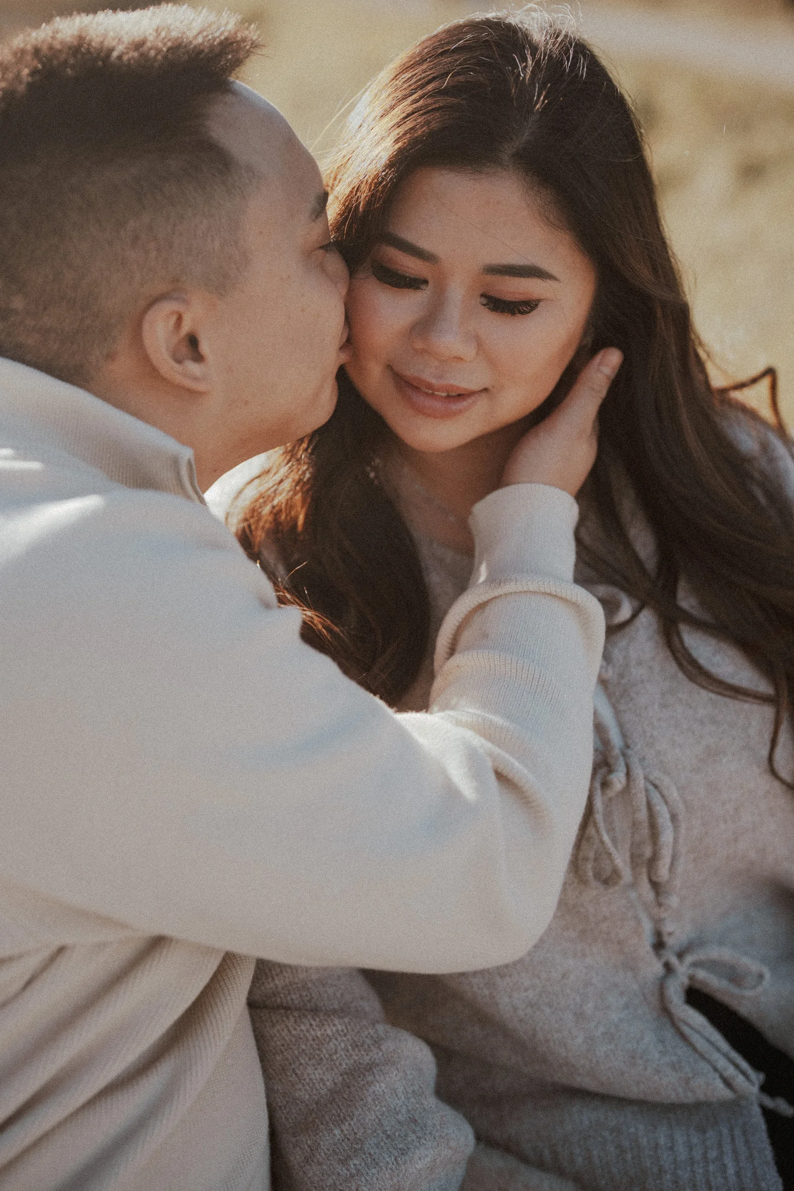 Close-up of groom kissing bride's cheek, intimate and tender moment.