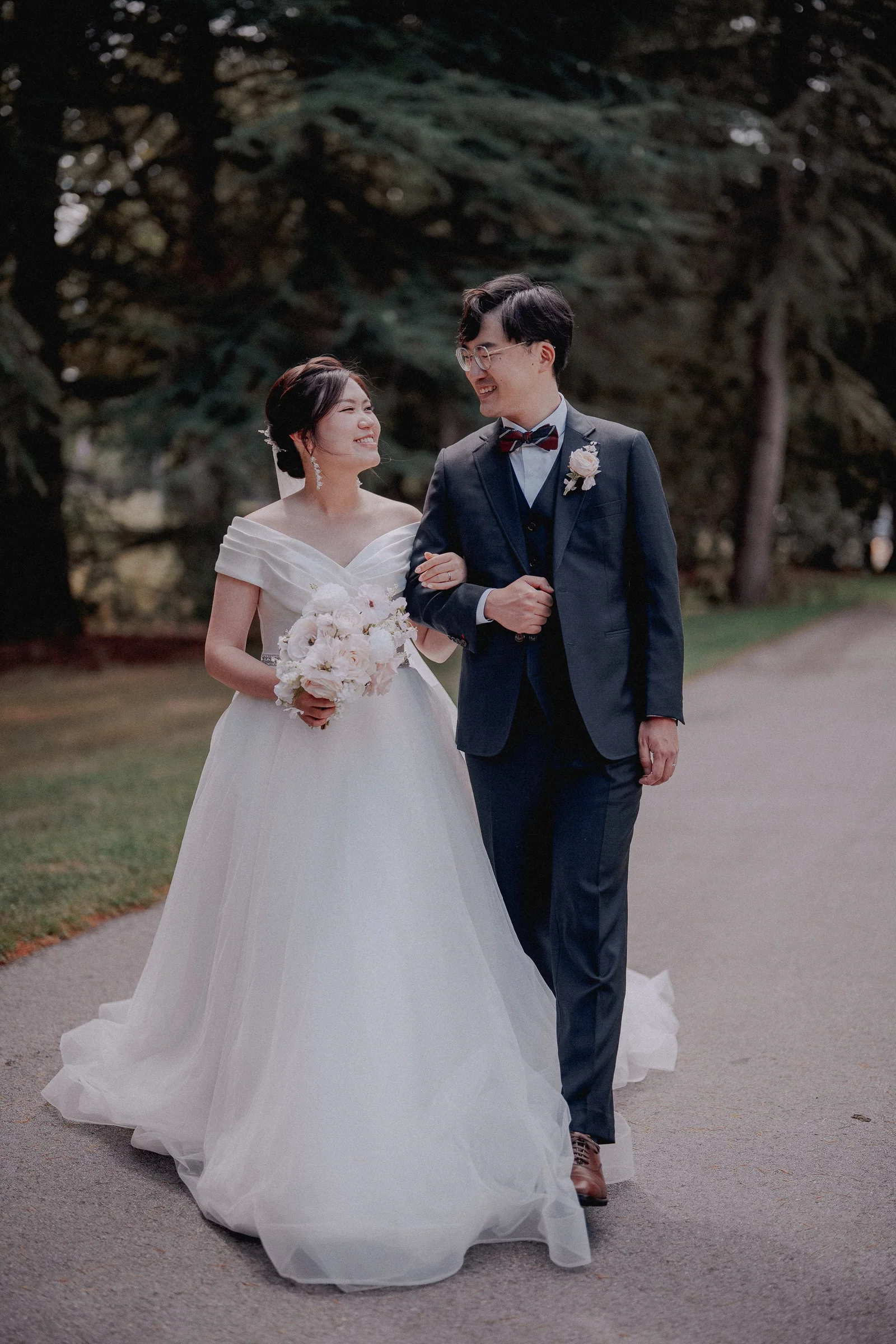 Couple smiling at each other as they walk through the chapel grounds.