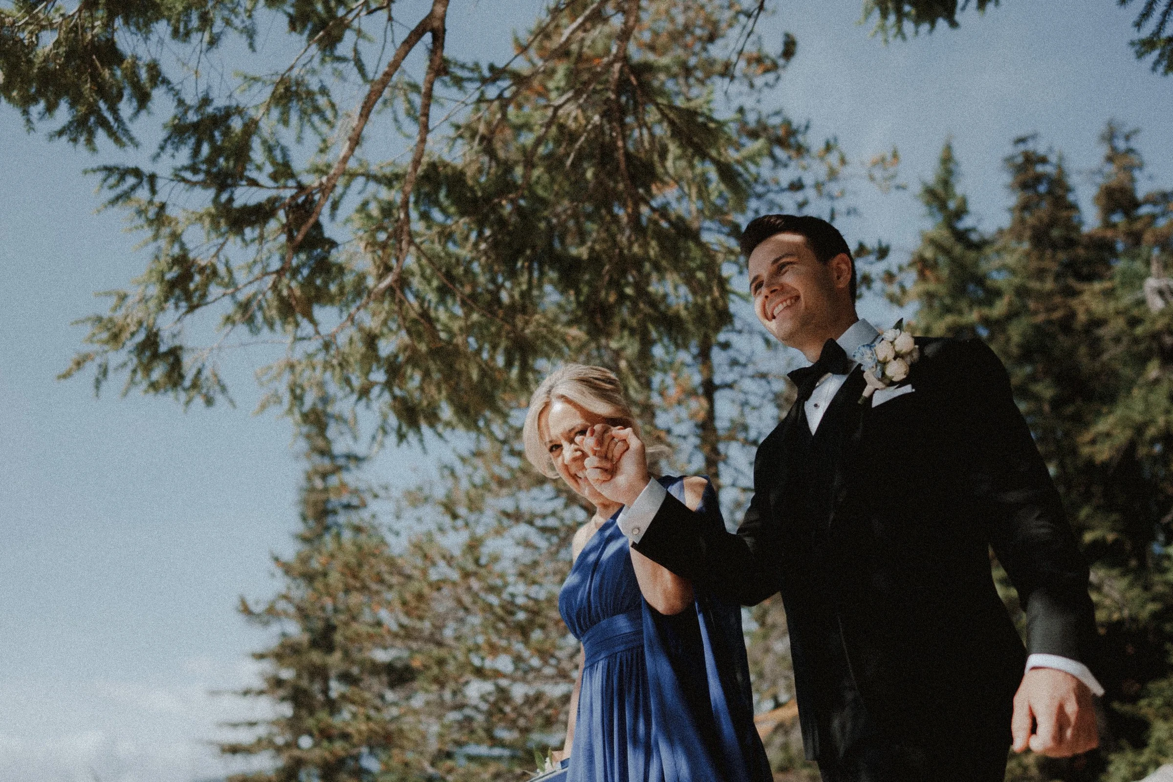 Groom walking down aisle with mother, smiling at Sea to Sky mountain wedding ceremony.