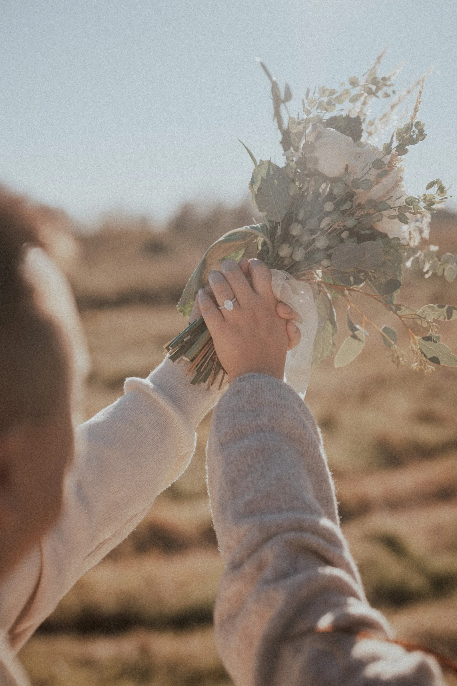 Bride holding bouquet with engagement ring visible, Pitt Lake scenery.