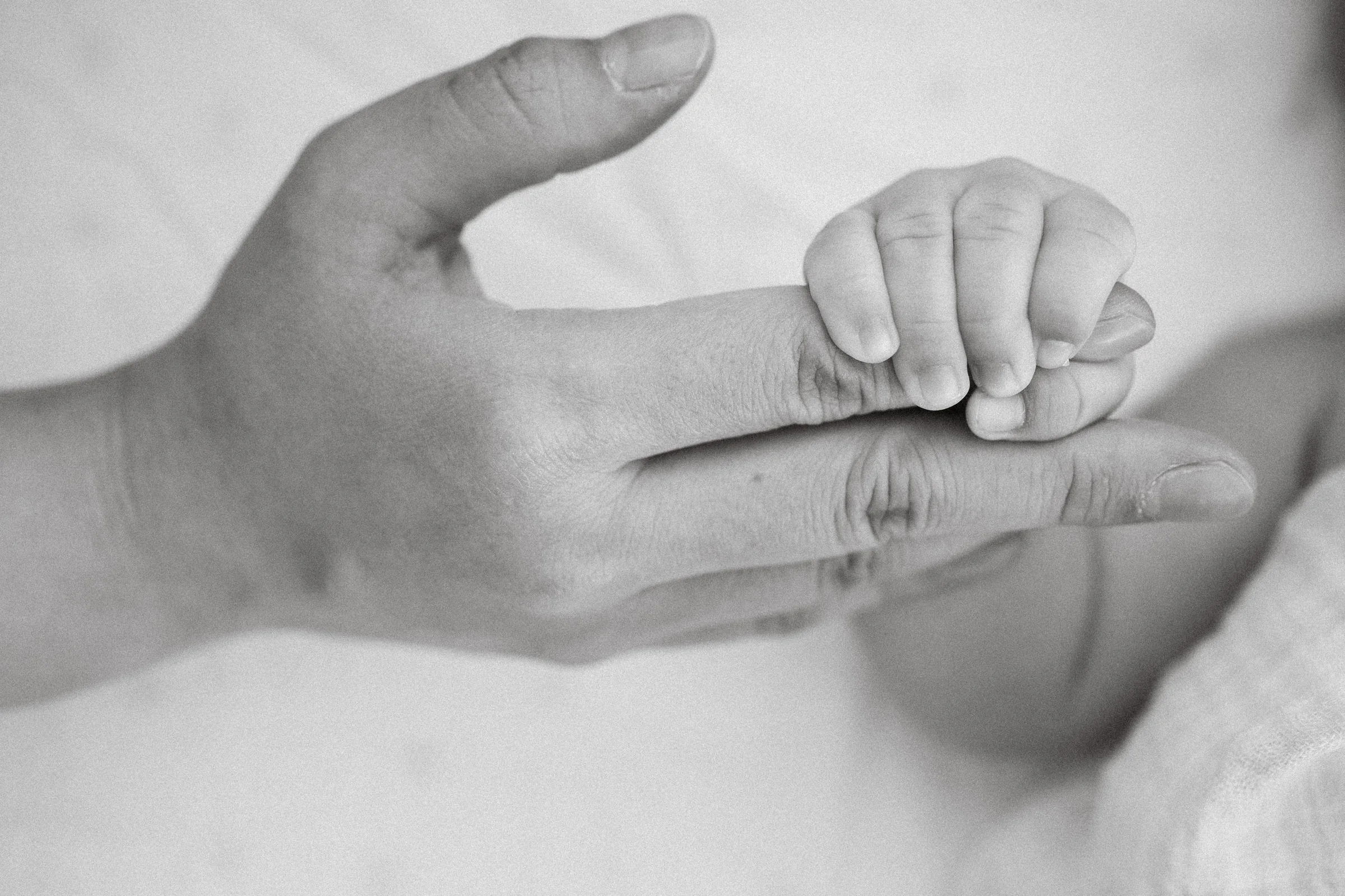  Tiny hand, big connection: A beautiful, candid close-up of the newborn baby's hand gently grasping a parent's finger. 