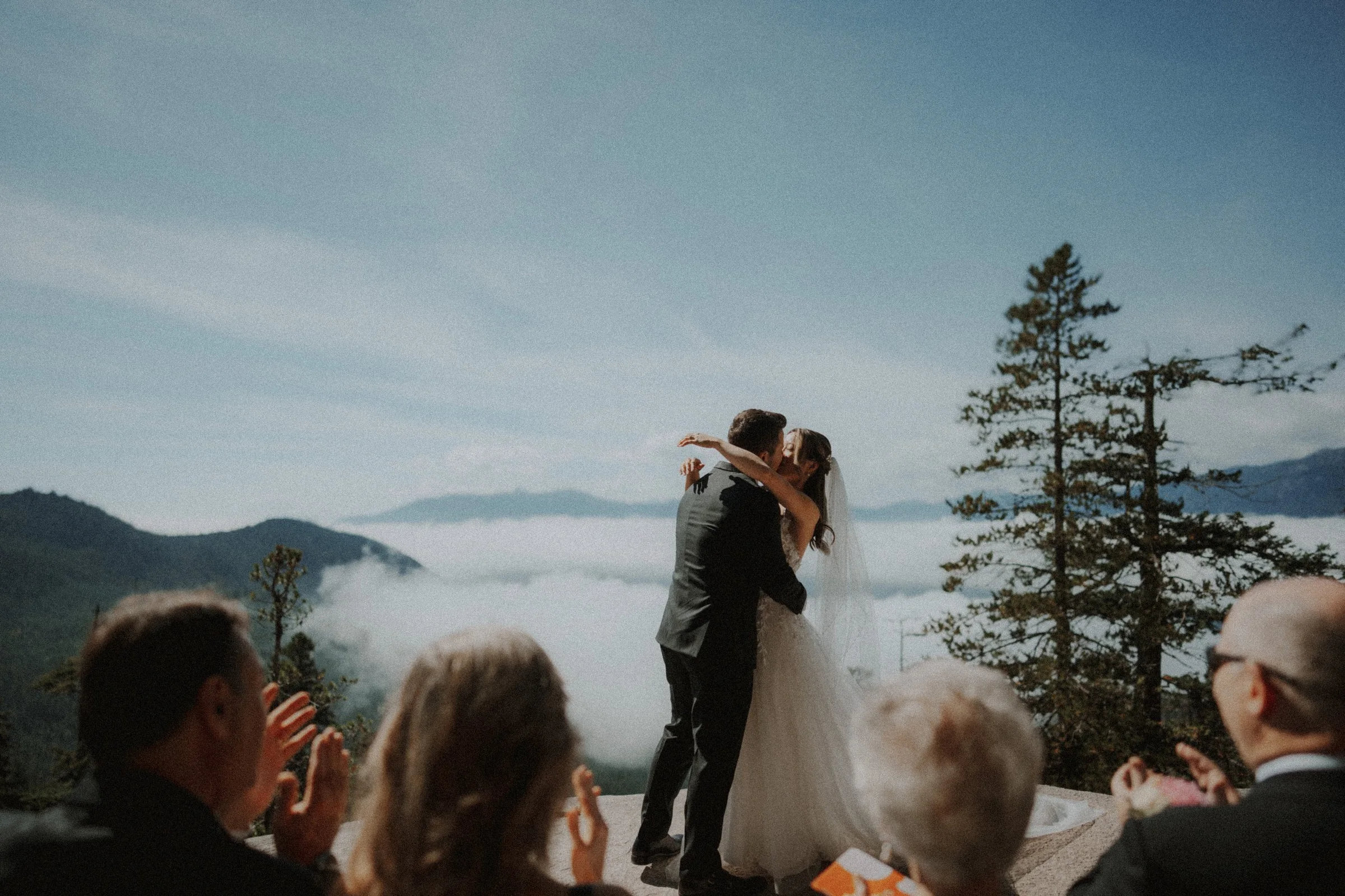 Couple embracing after exchanging vows above the mountain valley.