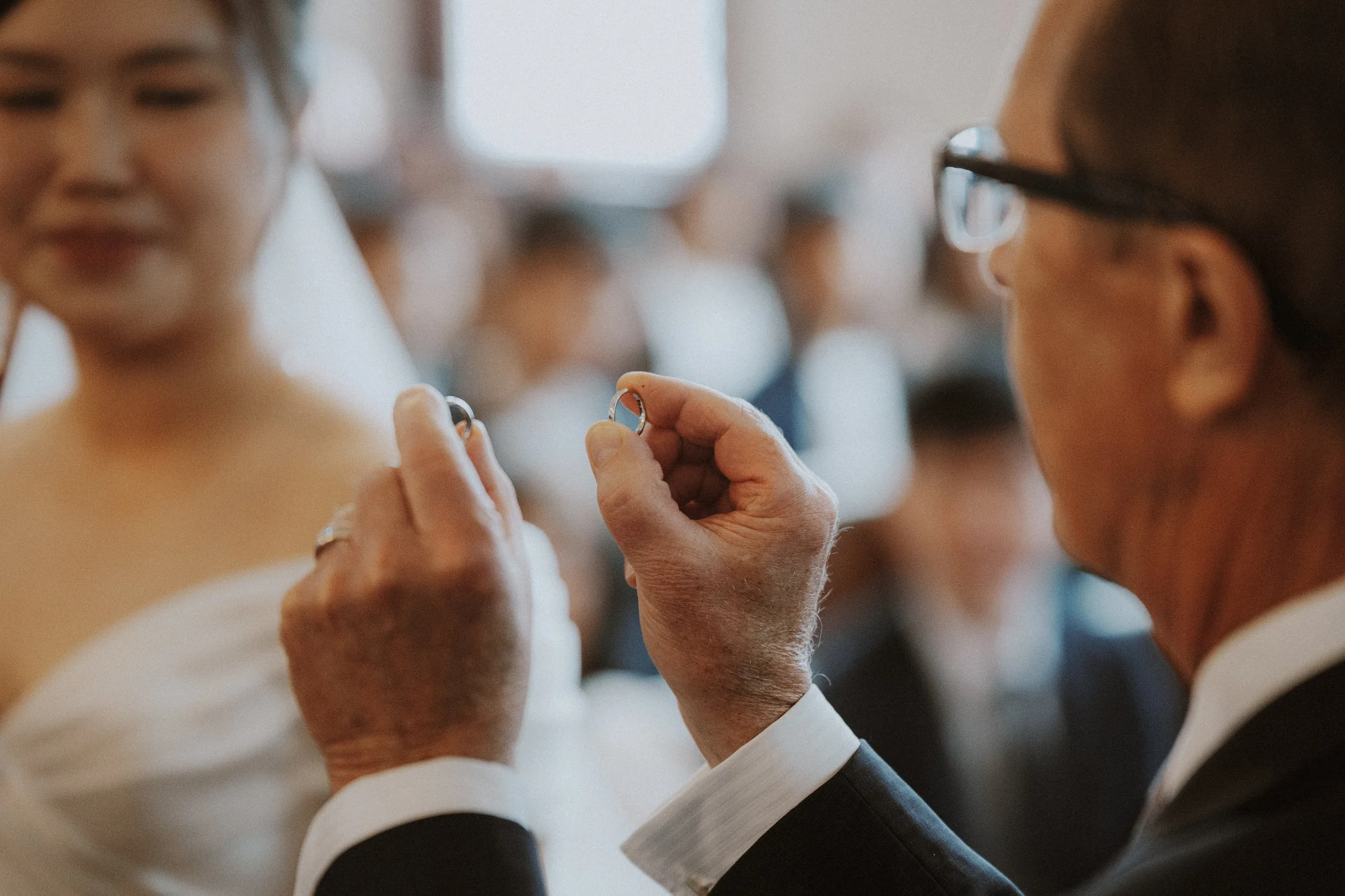 Close-up of the officiant holding the wedding rings, candid moment.