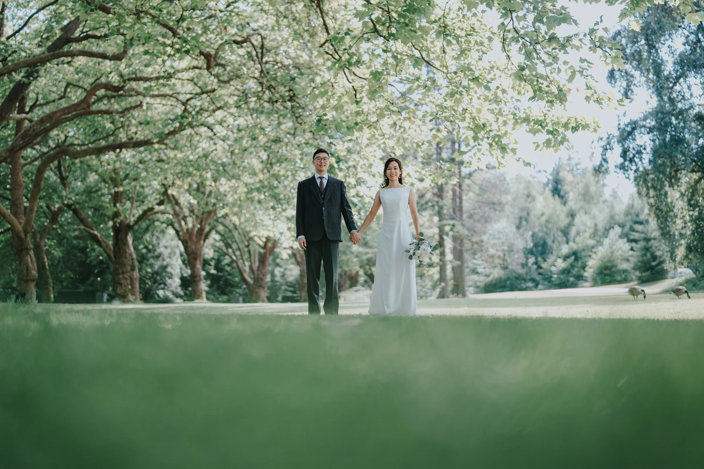 Chloe and Marco walking beneath the trees at Stanley Park, Vancouver
