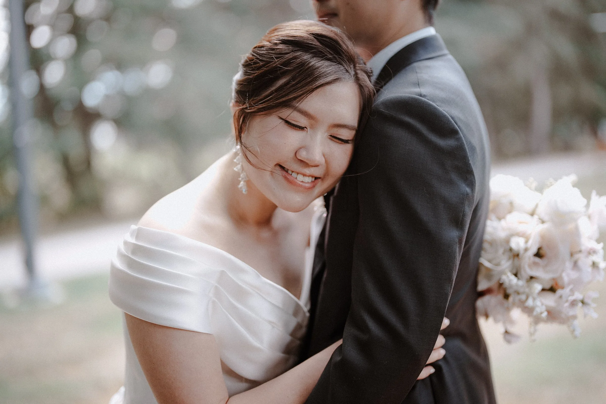 Bride resting her head against the groom's chest and smiling.
